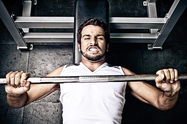 Man lifting heavy weights Too much, too soon - Man lifting heavy weights