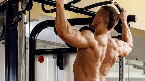 shirtless man doing pull-ups
