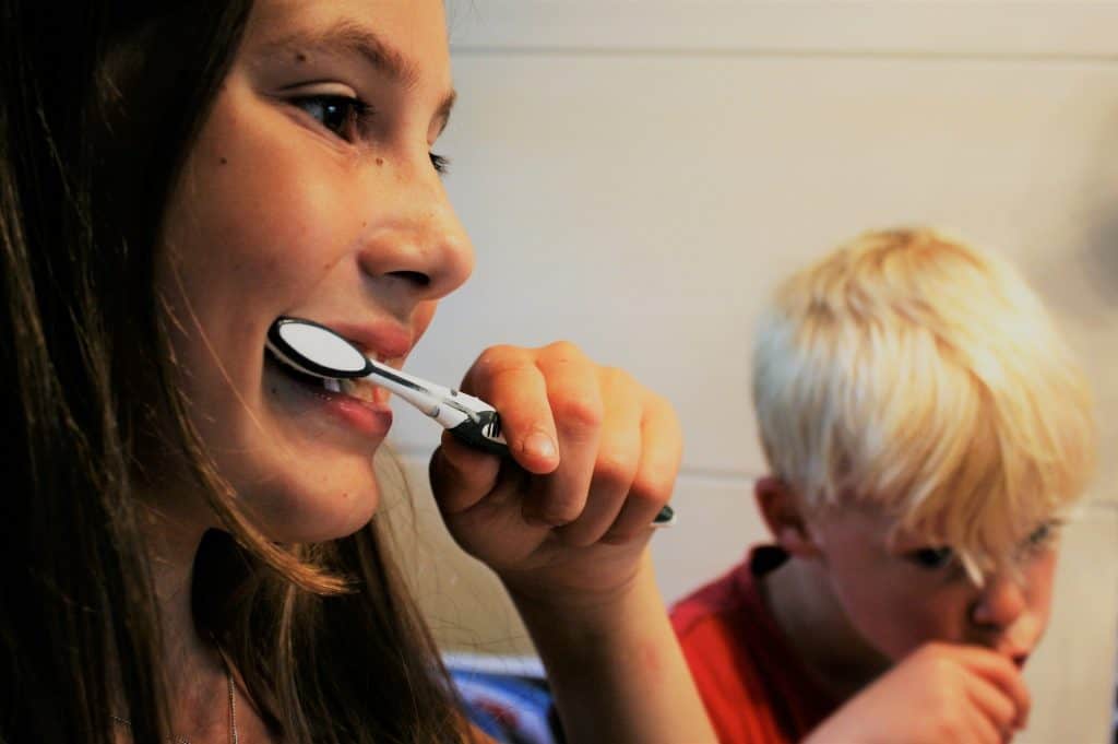 Child and mother brushing teeth together